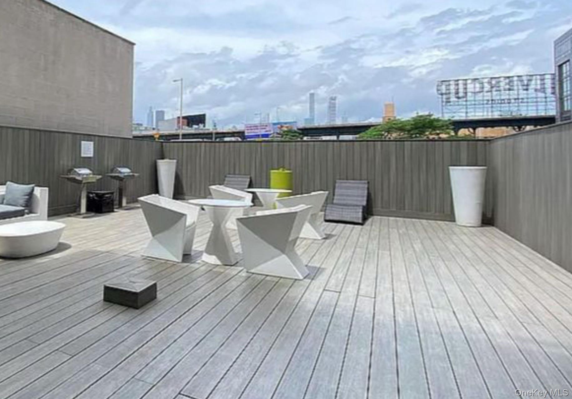 24-12 42nd Road, Unit 6C Queens, NY 11101 - Photo 11 of 12 a view of a terrace with wooden floor