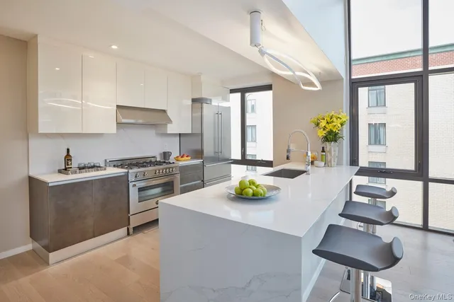 a kitchen with stainless steel appliances a sink a stove and cabinets