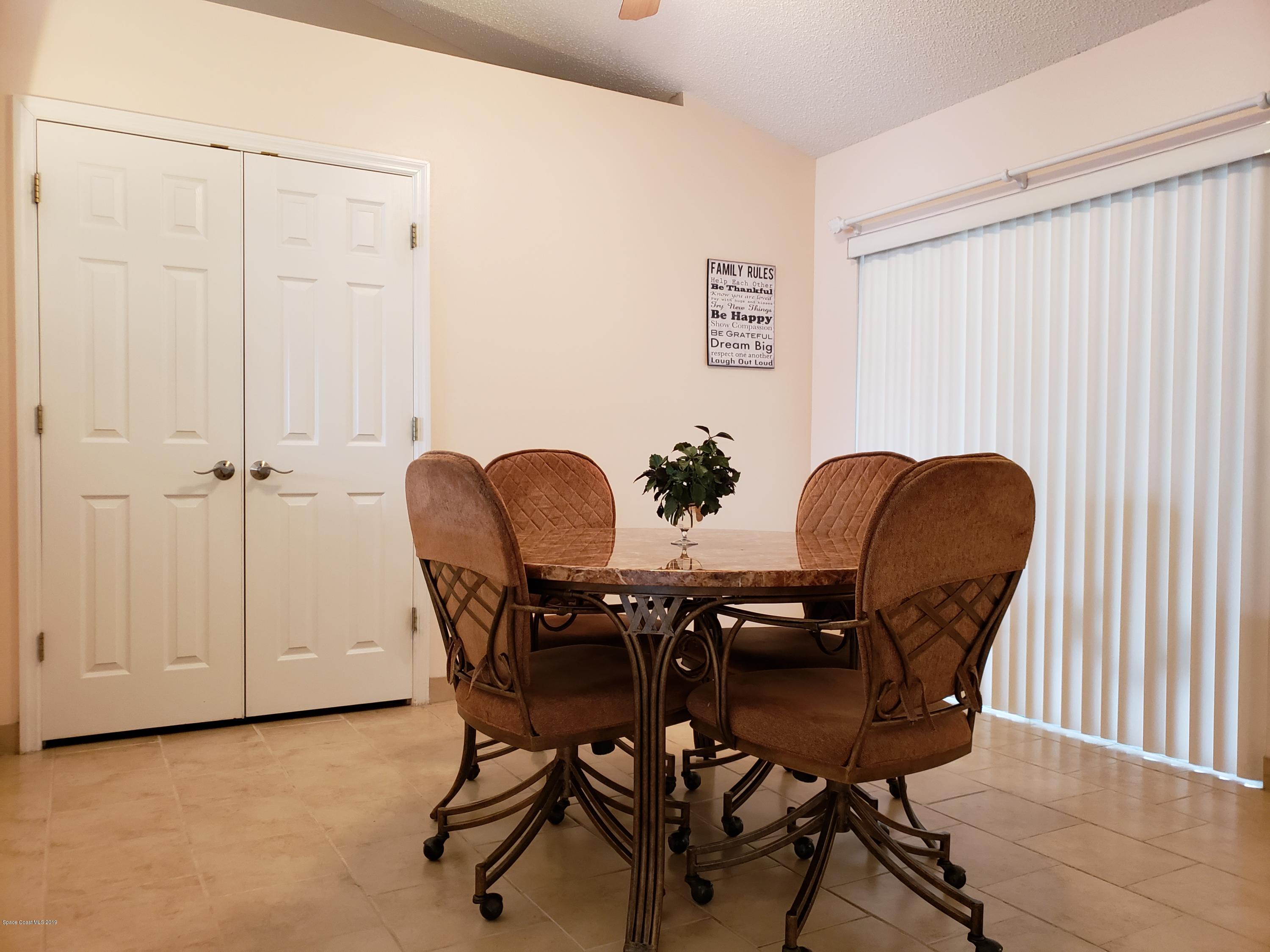 6145 Adina Road Cocoa, FL 32927 - Photo 12 of 34 a view of a dining room with furniture and a chandelier