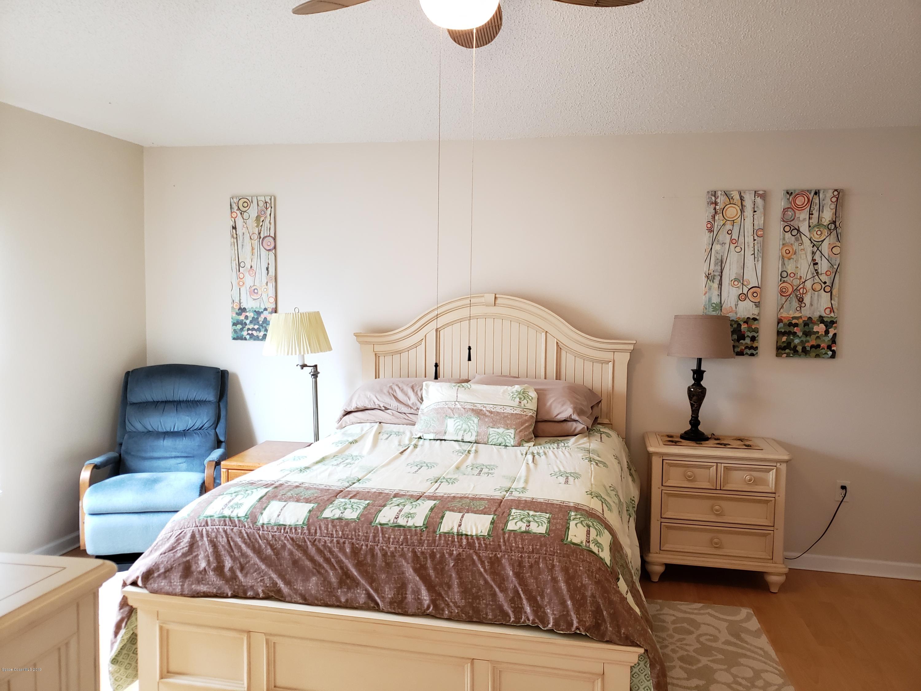 6145 Adina Road Cocoa, FL 32927 - Photo 16 of 34 a bedroom with a bed a couch and dresser