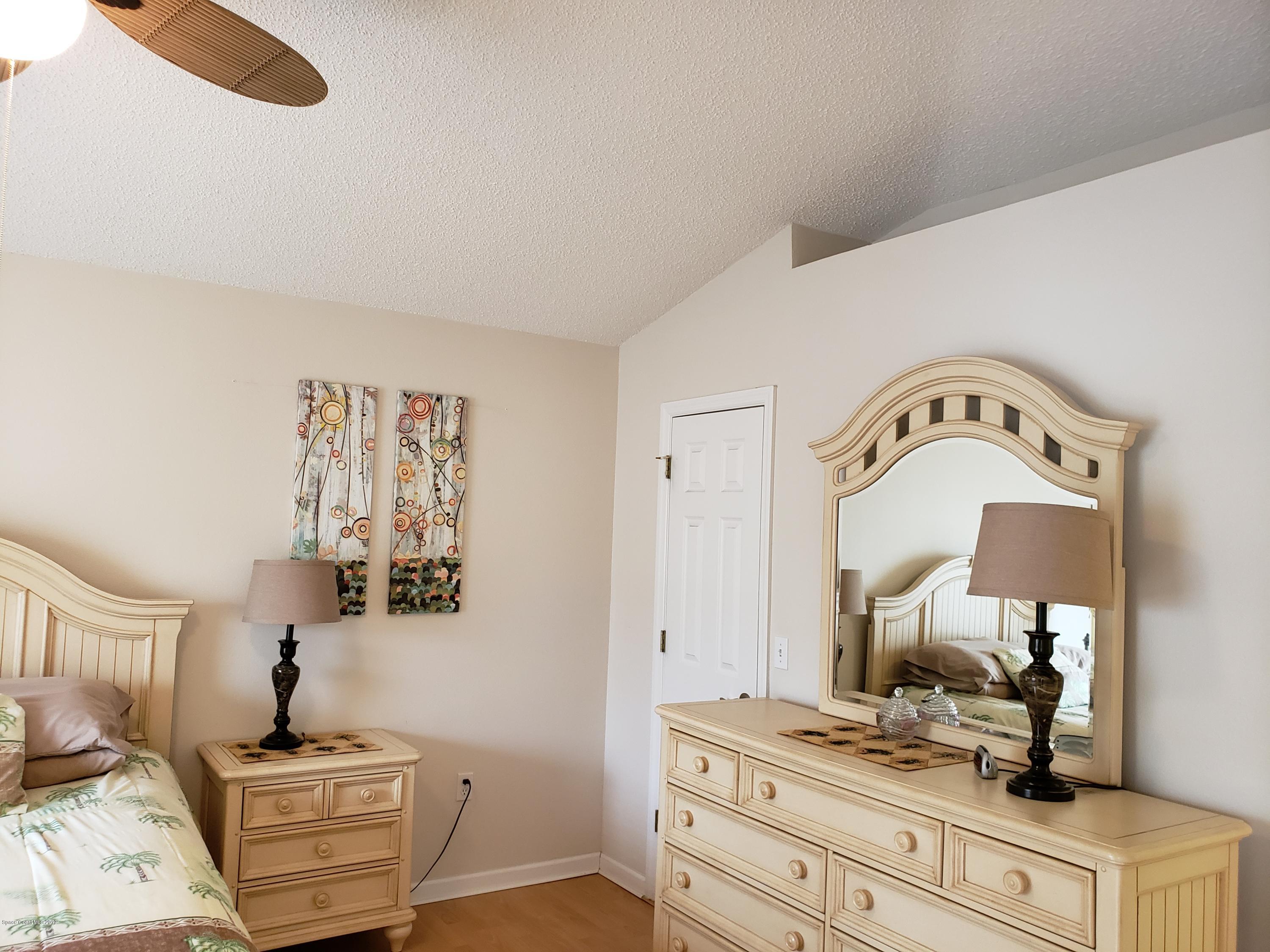 6145 Adina Road Cocoa, FL 32927 - Photo 17 of 34 a room with a bed and a mirror