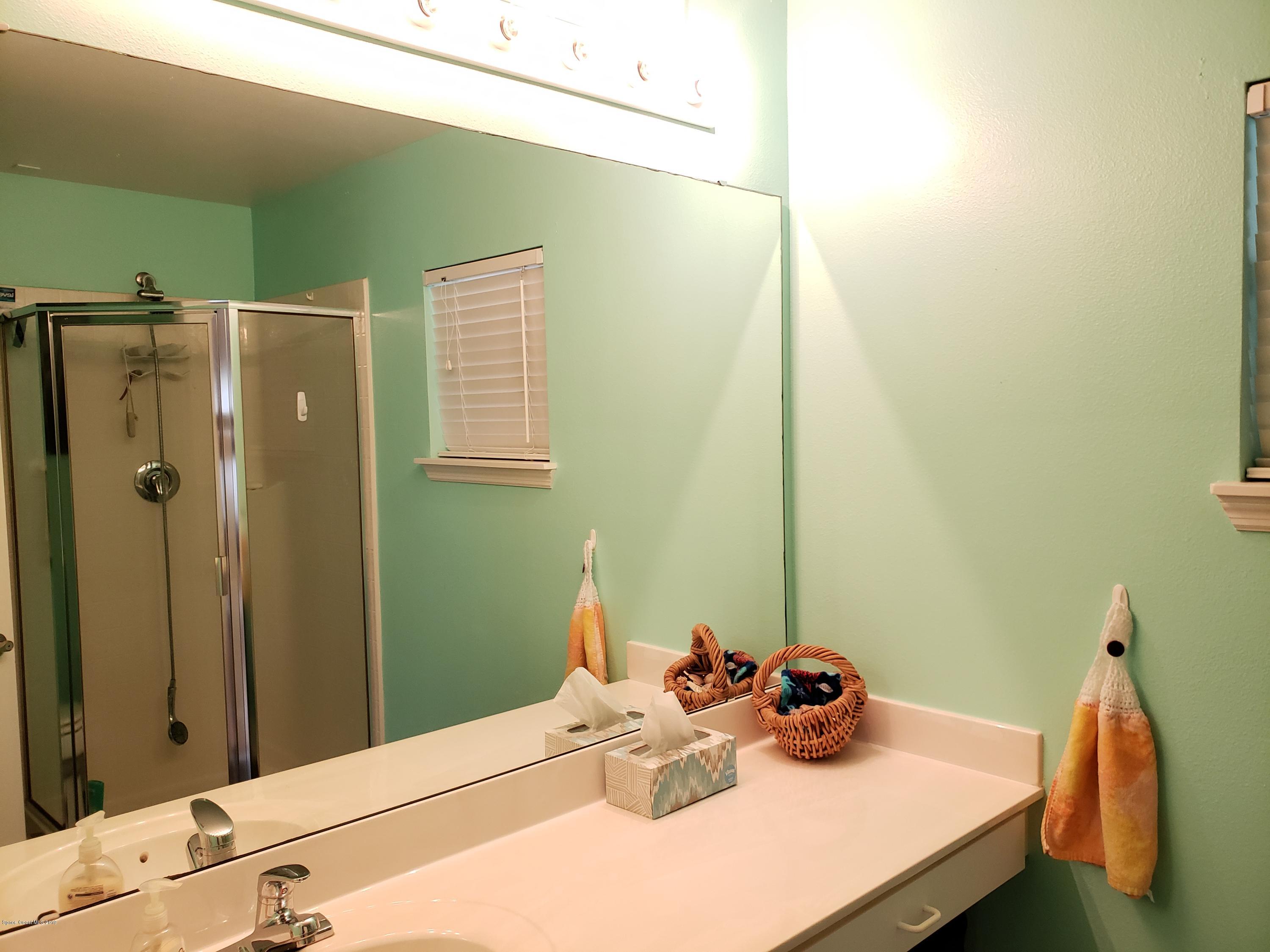 6145 Adina Road Cocoa, FL 32927 - Photo 18 of 34 a bathroom with a sink and a mirror