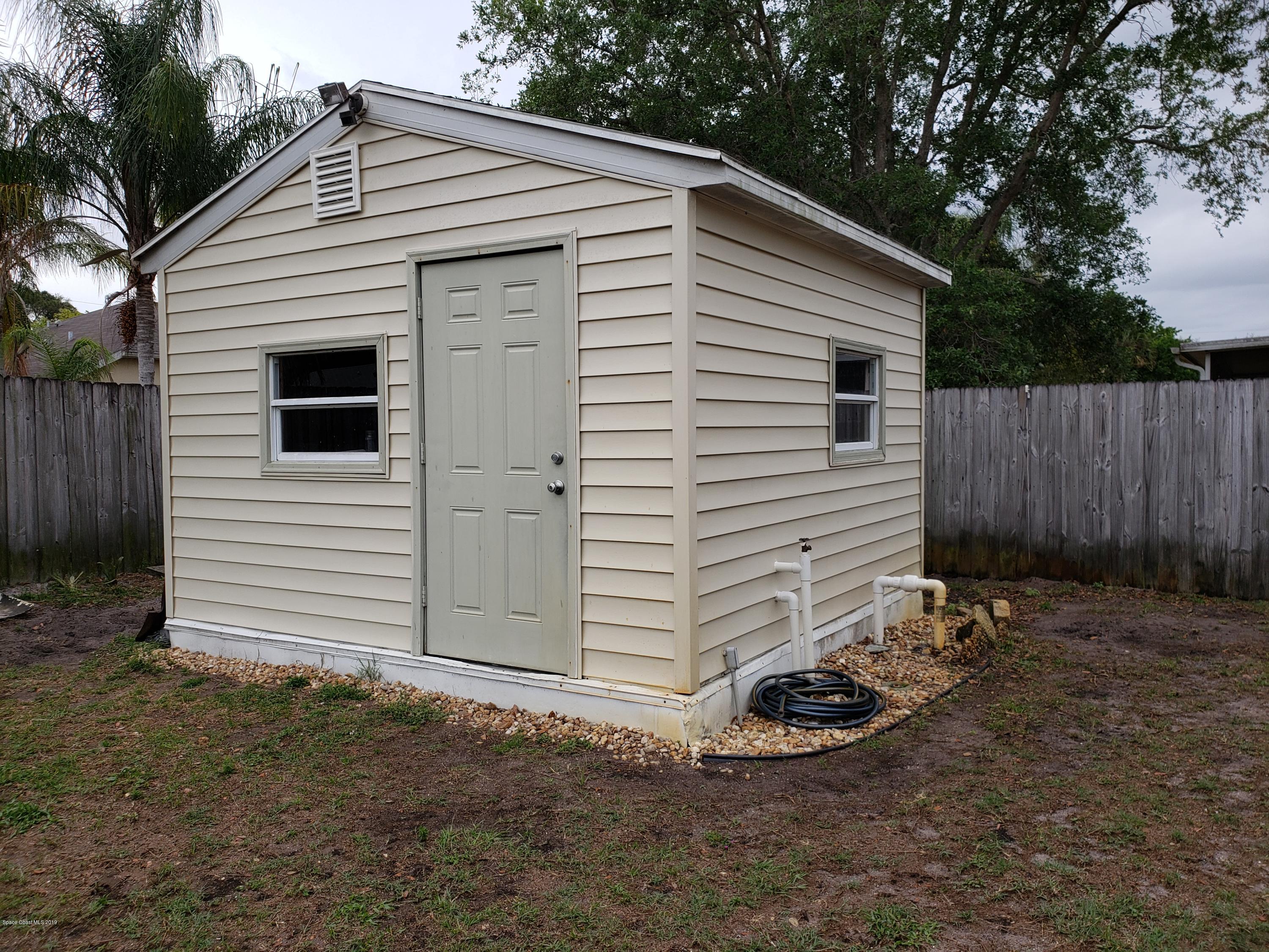 6145 Adina Road Cocoa, FL 32927 - Photo 24 of 34 a view of a small house with a yard