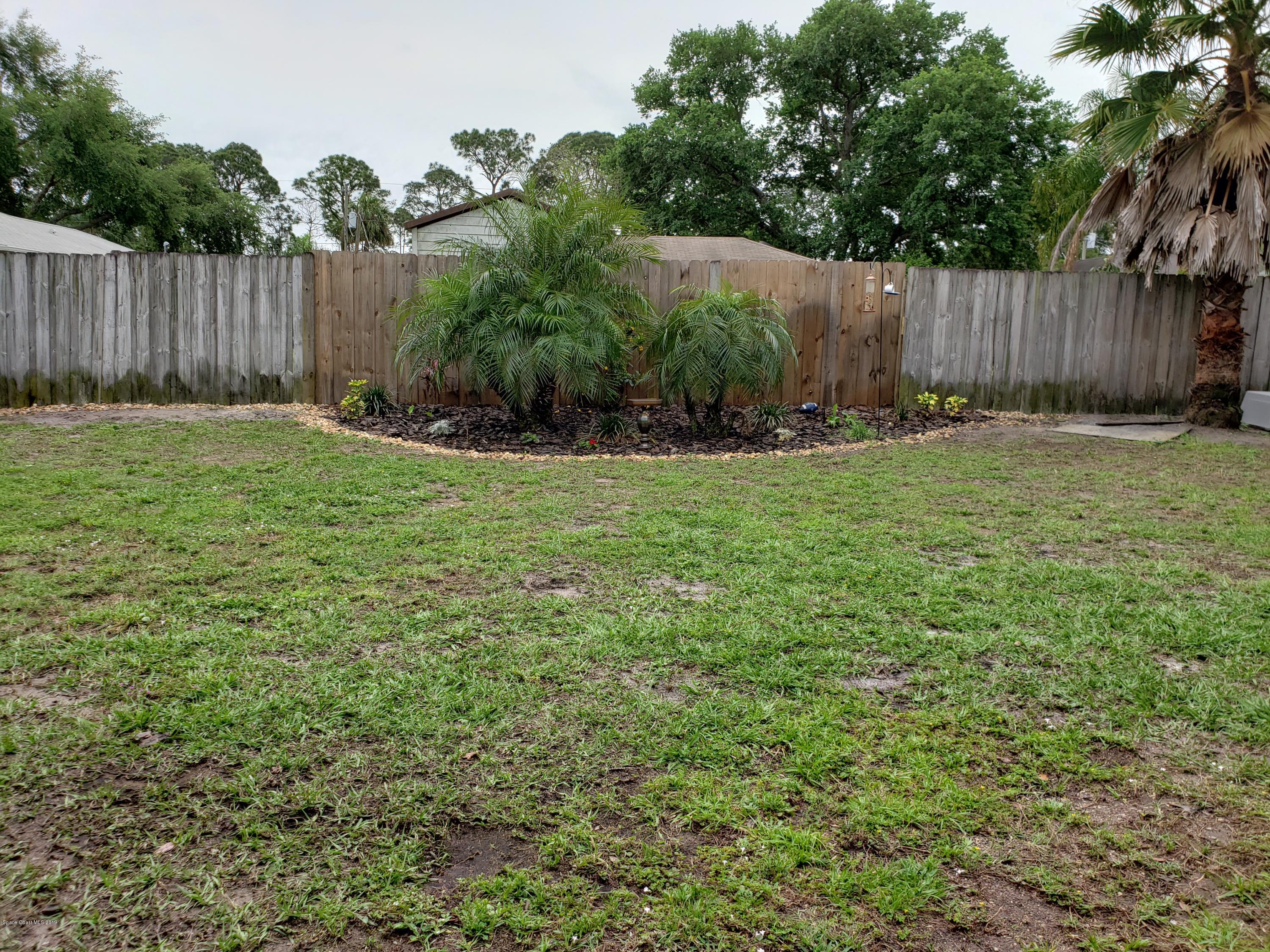 6145 Adina Road Cocoa, FL 32927 - Photo 28 of 34 a view of backyard with potted plants and wooden fence