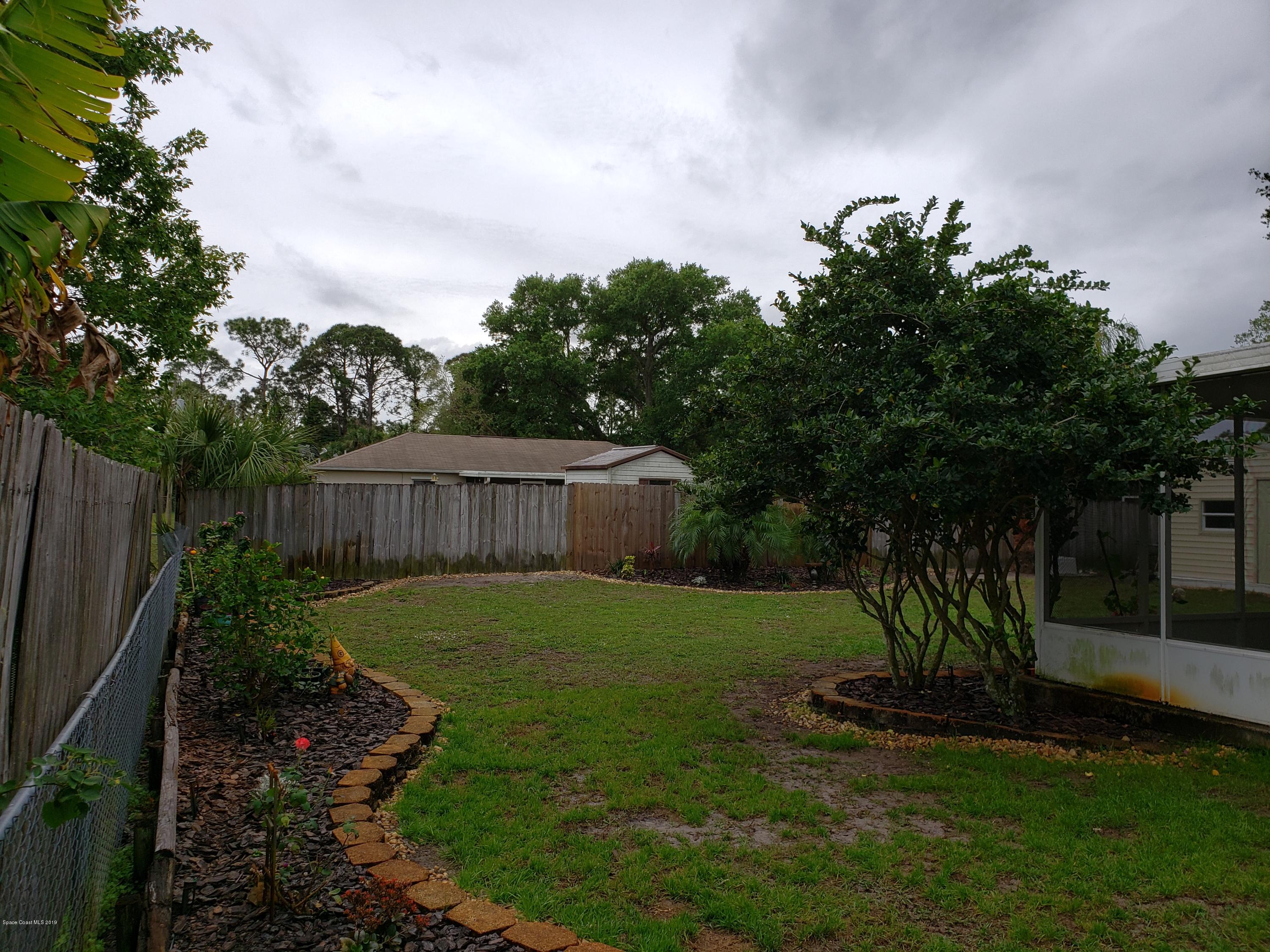 6145 Adina Road Cocoa, FL 32927 - Photo 29 of 34 a view of a backyard with plants and large trees