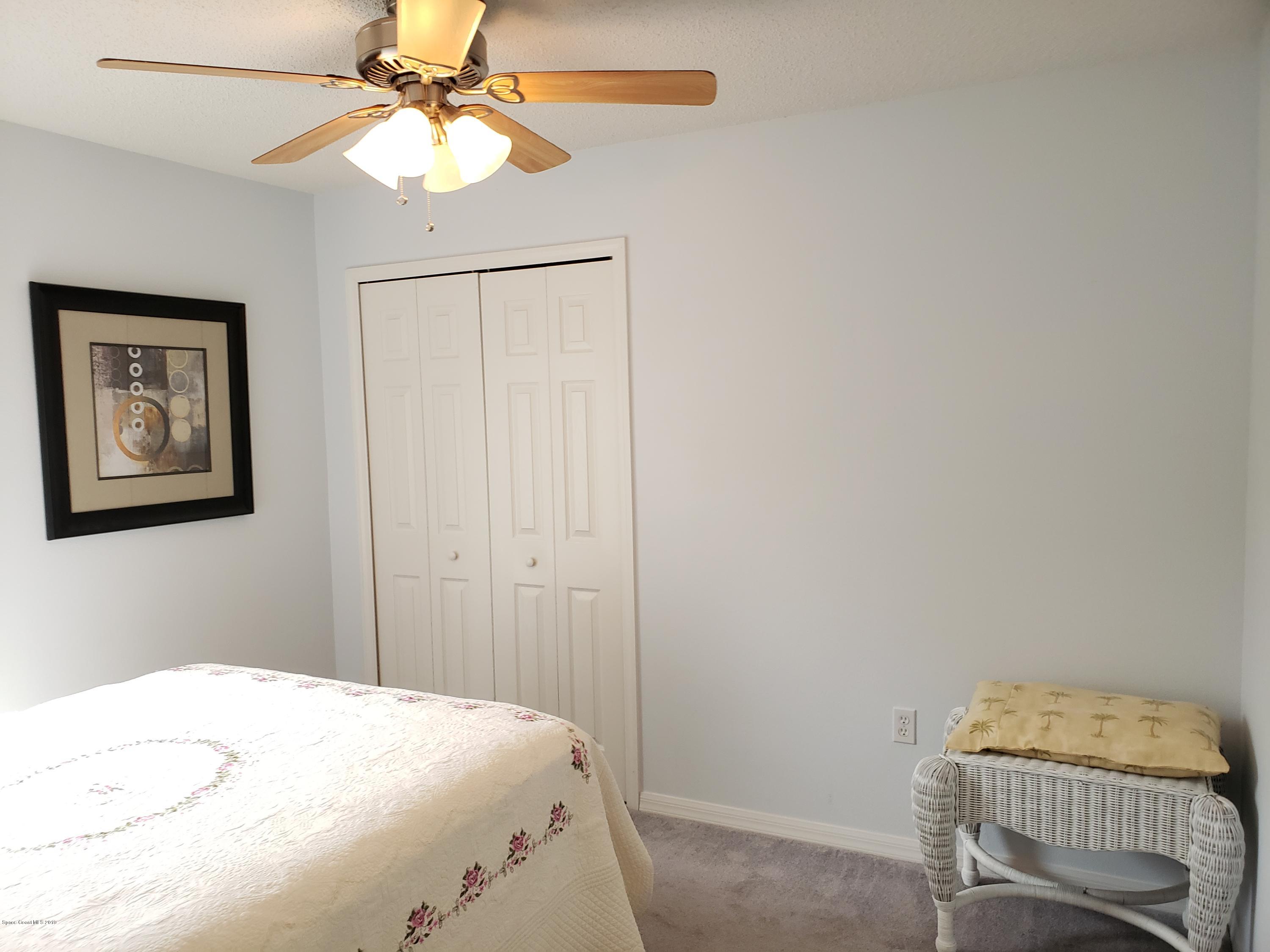 6145 Adina Road Cocoa, FL 32927 - Photo 7 of 34 a bedroom with a bed and a chandelier