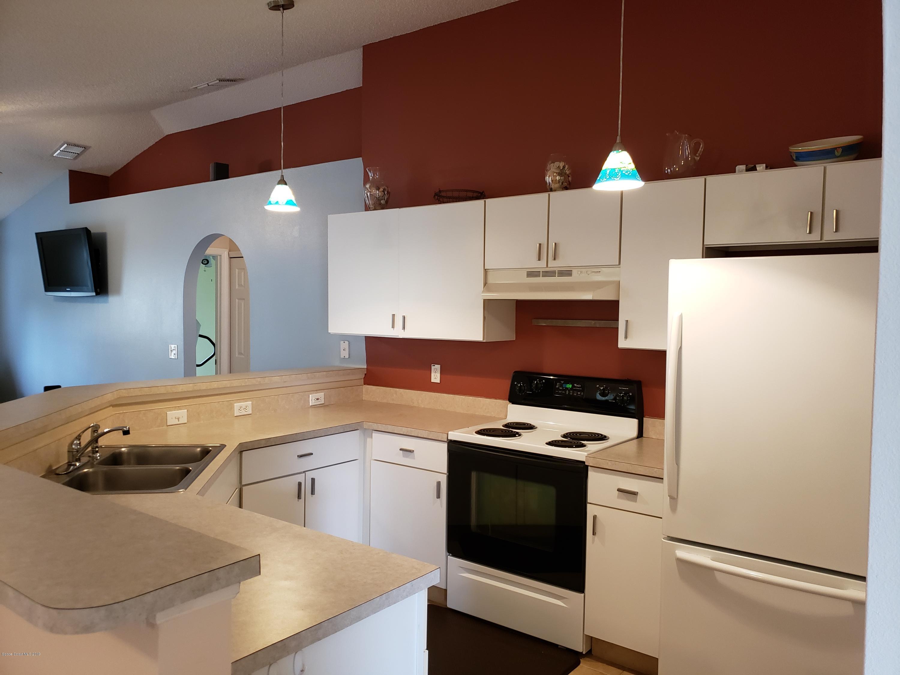 6145 Adina Road Cocoa, FL 32927 - Photo 9 of 34 a kitchen with a sink a stove and refrigerator
