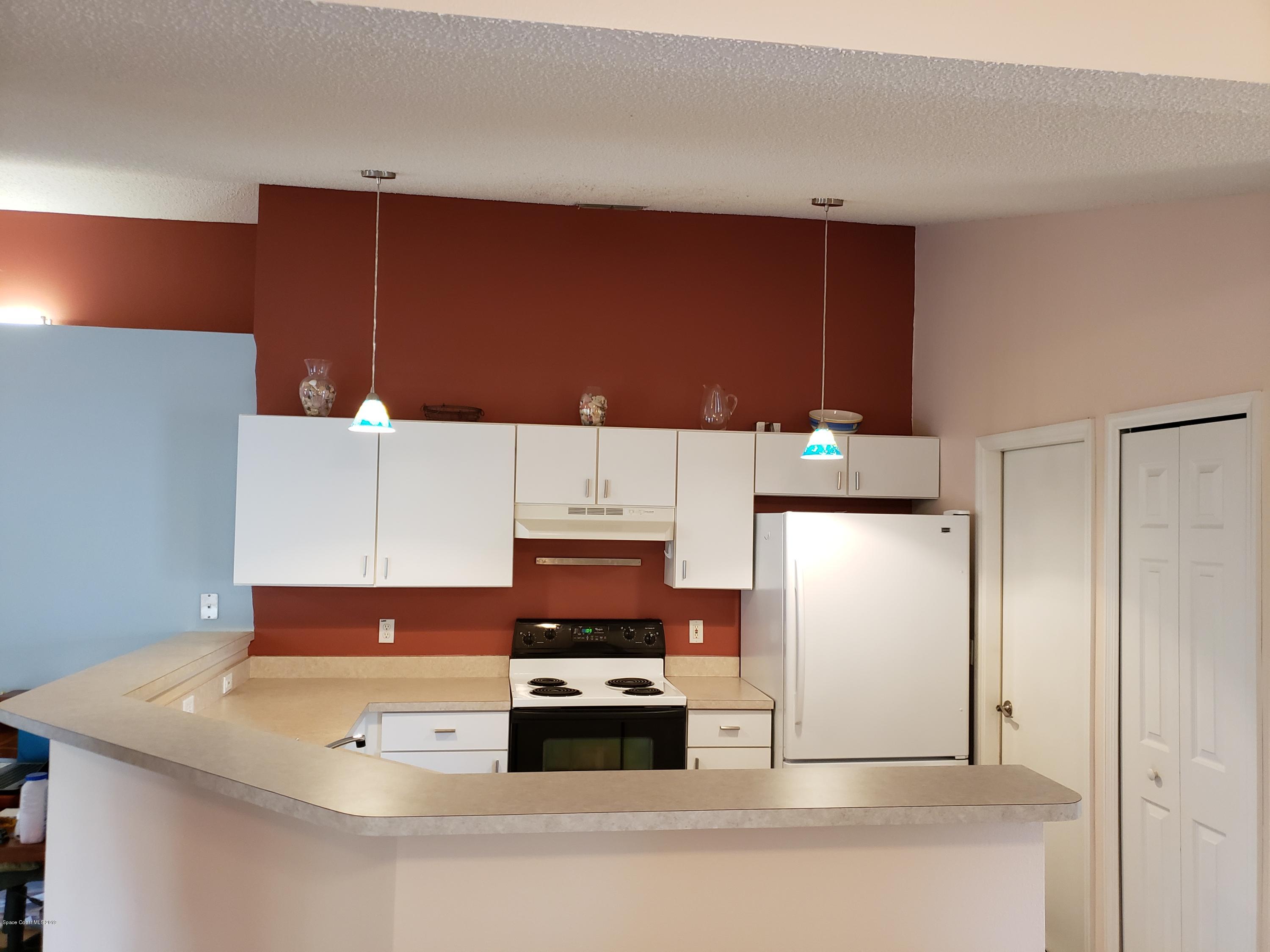 6145 Adina Road Cocoa, FL 32927 - Photo 10 of 34 a kitchen with stainless steel appliances a refrigerator a stove and a refrigerator