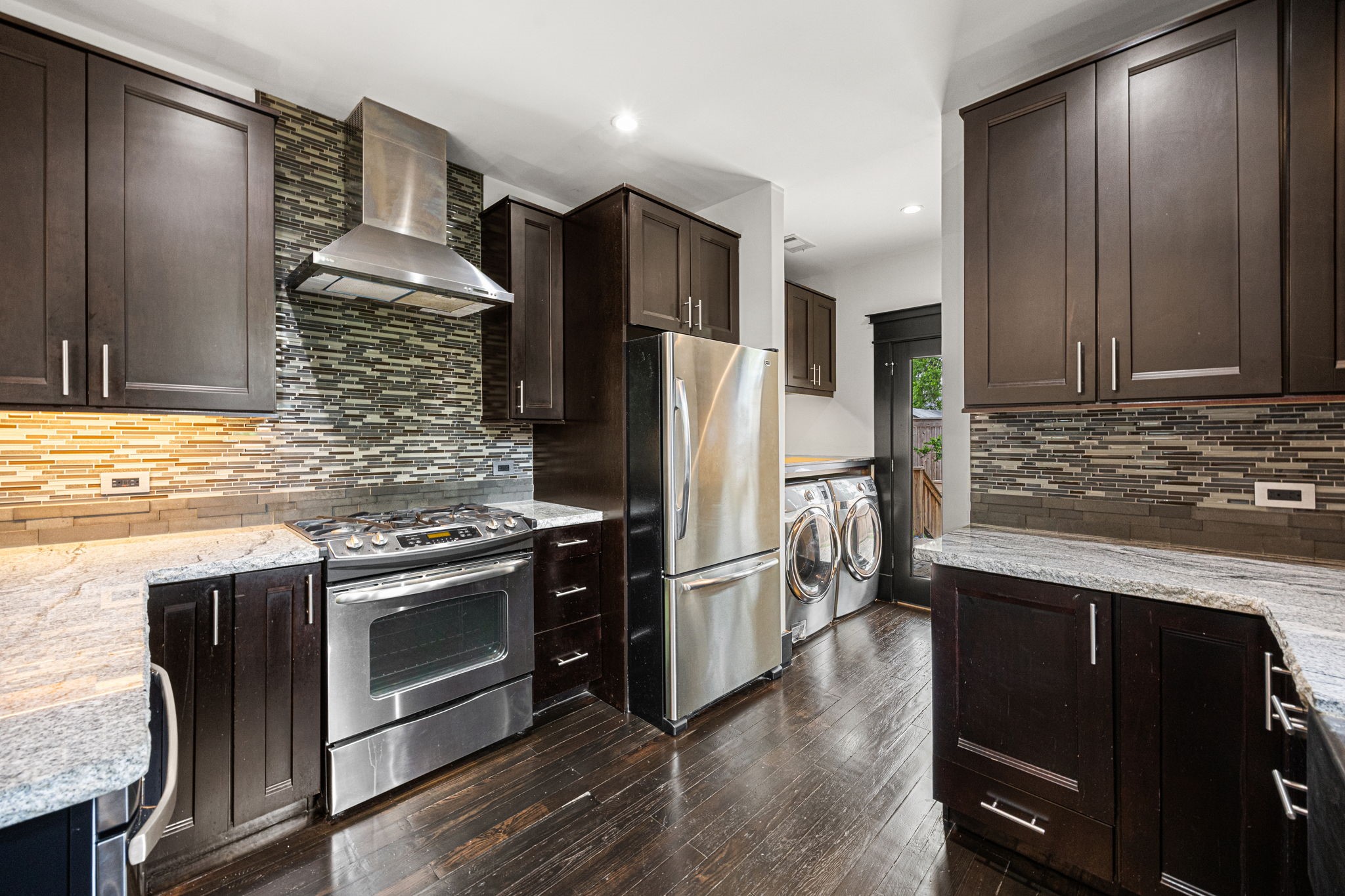 1115 Adele Street Houston, TX 77009 - Photo 2 of 19 Kitchen featuring stainless steel appliances, gas range, vent hood, and modern tile backsplash.