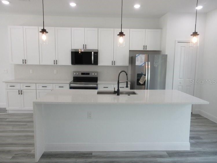 6765 Southwest 152nd Lane Road Ocala, FL 34473 - Photo 4 of 14 a kitchen with stainless steel appliances a sink a stove a refrigerator and cabinets