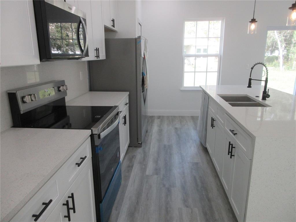 6765 Southwest 152nd Lane Road Ocala, FL 34473 - Photo 5 of 14 a kitchen with granite countertop a sink stove and refrigerator