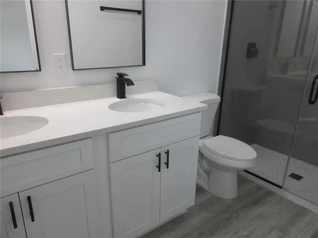 a bathroom with a sink a toilet and mirror