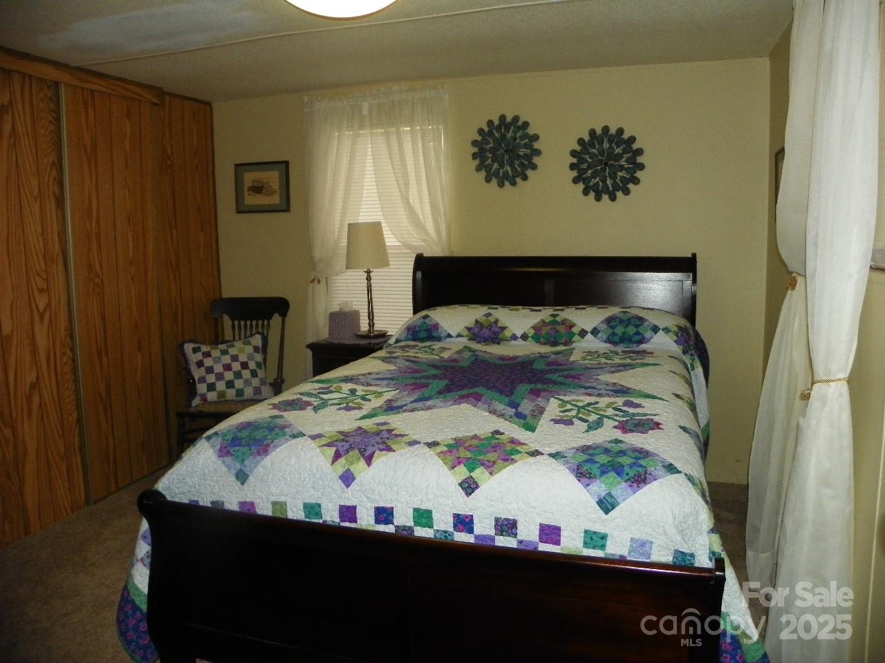 116 3rd Avenue New London, NC 28127 - Photo 15 of 18 a bed sitting in a bedroom next to a wooden door