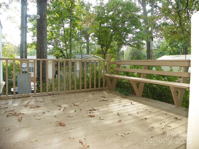 a view of a backyard with large trees and wooden fence