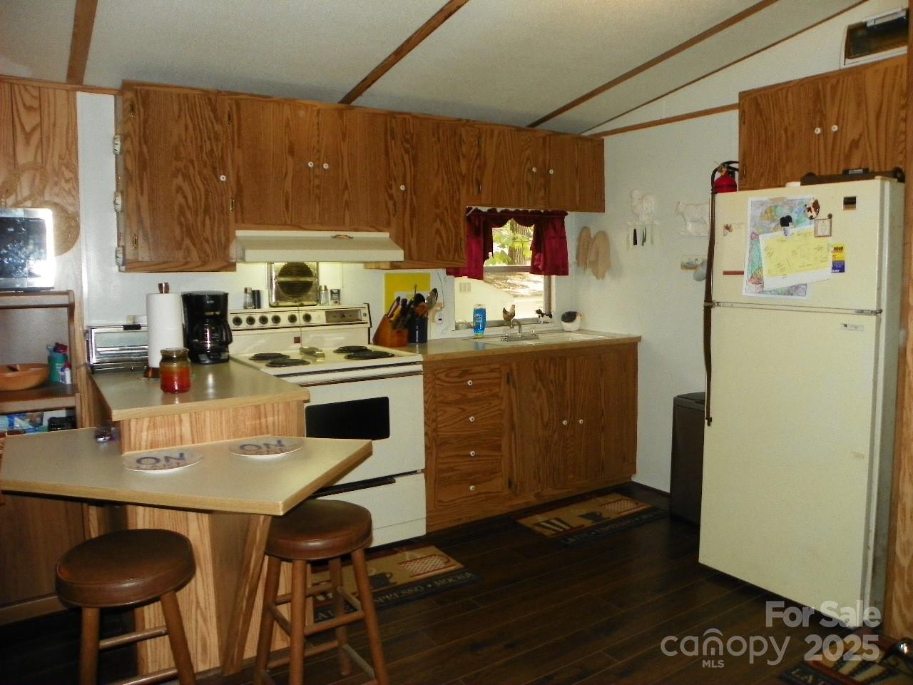 116 3rd Avenue New London, NC 28127 - Photo 10 of 18 a kitchen with stainless steel appliances a stove a refrigerator a sink a dining table and chairs with wooden floor