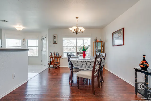 a view of a dining room with furniture a chandelier and wooden floor