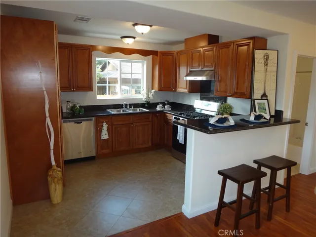 a kitchen with stainless steel appliances granite countertop a stove a sink dishwasher and a refrigerator