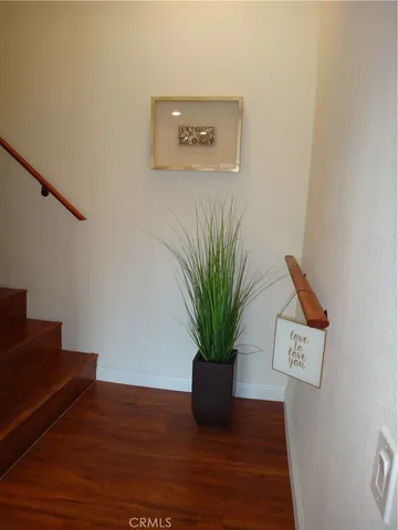 a view of a hallway with wooden floor and glass top table