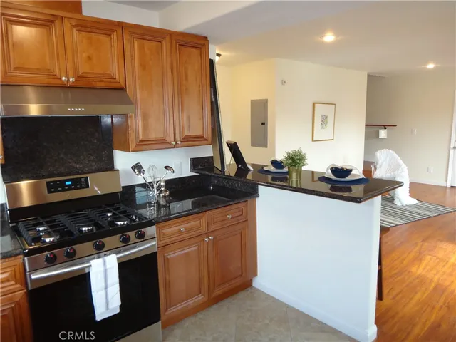 a kitchen with stainless steel appliances granite countertop a sink stove and cabinets
