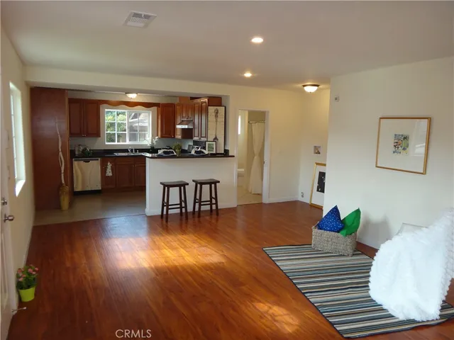 a living room with dining room and wooden floor