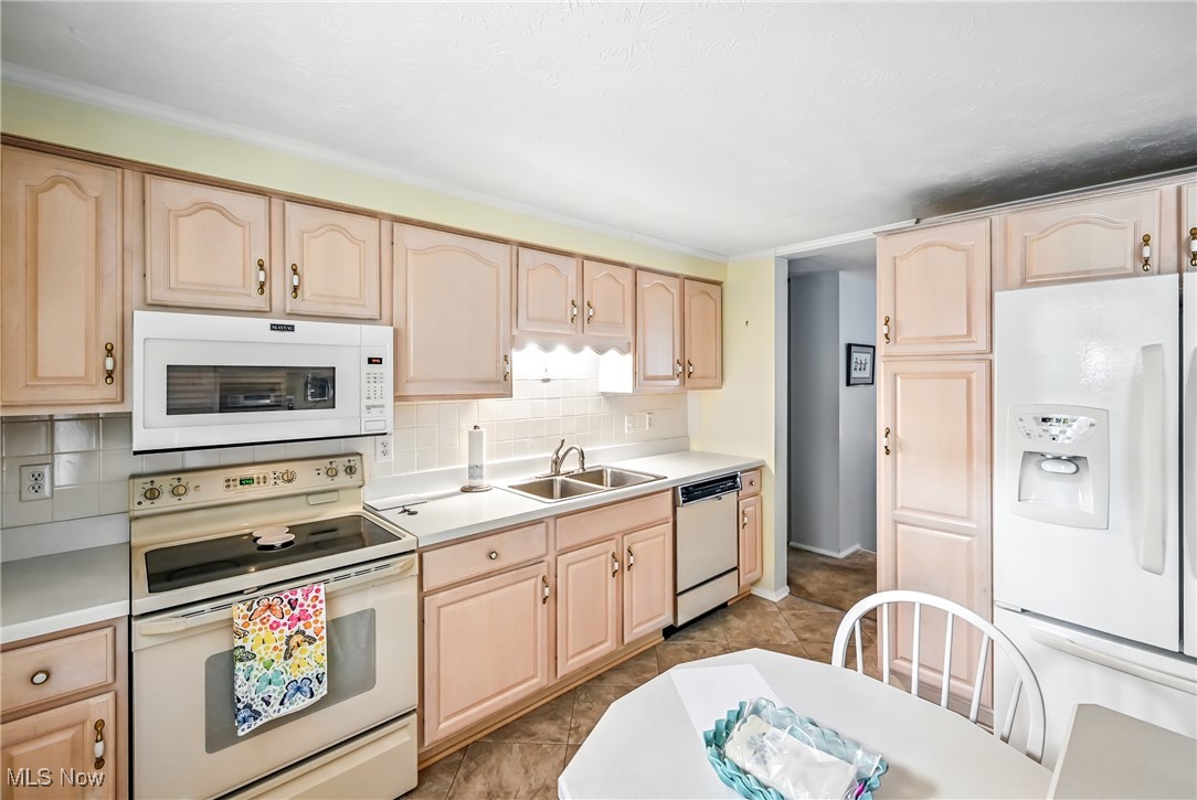 7797 Raglan Drive Northeast Warren, OH 44484 - Photo 28 of 50 Kitchen with light brown cabinetry, white appliances, and light countertops
