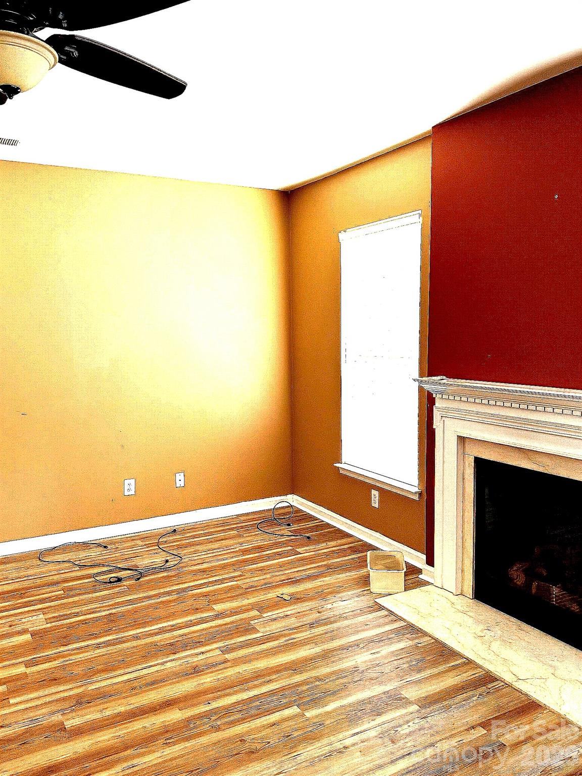 6006 Brook Valley Run Monroe, NC 28110 - Photo 12 of 27 a view of an empty room with wooden floor and a fireplace