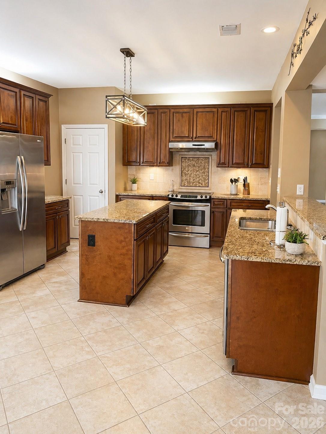 6006 Brook Valley Run Monroe, NC 28110 - Photo 5 of 27 a large kitchen with stainless steel appliances granite countertop a stove top oven a sink dishwasher and a refrigerator