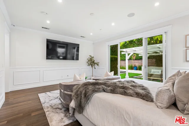 a spacious bedroom with a large bed and a flat screen tv