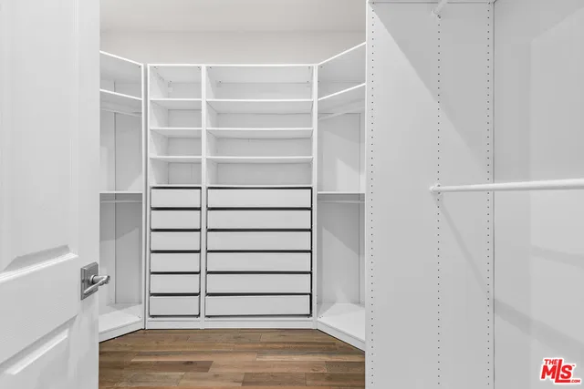 a view of walk in closet with empty racks