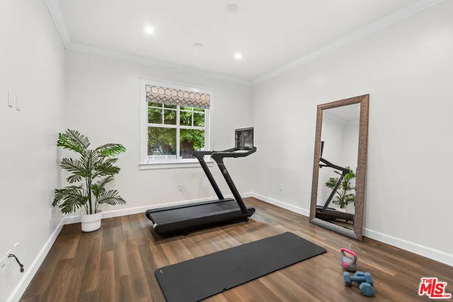 a room with gym equipment with wooden floor
