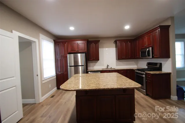 a kitchen with refrigerator cabinets and wooden floor