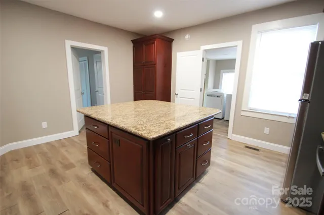 a kitchen with a stove and a wooden floor