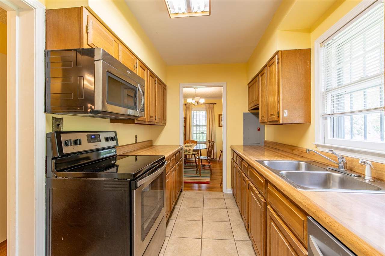 1191 Colonial Road Memphis, TN 38117 - Photo 12 of 24 Step Saver Galley Kitchen With New Stove, Dishwasher & Microwave. Fridge Stays. Newly Tiled Floor.