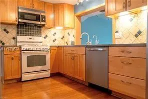 a kitchen with granite countertop cabinets stainless steel appliances and wooden floor