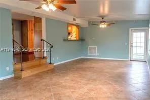 en empty room with windows and ceiling fan