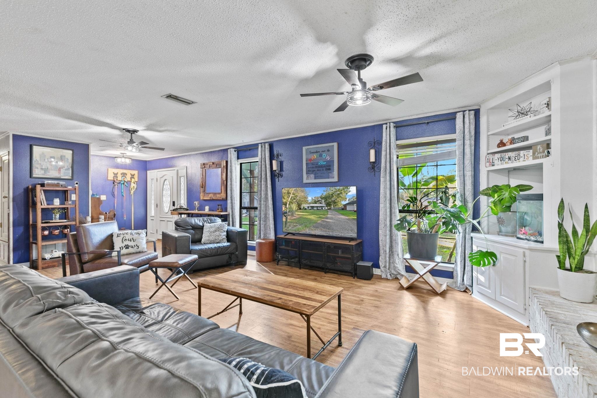 Living room featuring ceiling fan, wood finished floors, and a textured ceiling