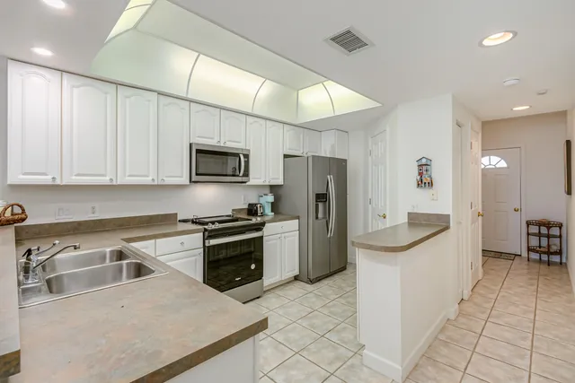 a kitchen with stainless steel appliances granite countertop a stove top oven a sink dishwasher and a microwave oven on the blue kitchen countertops