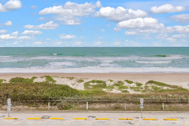a view of a swimming pool with a lawn chairs under an umbrella
