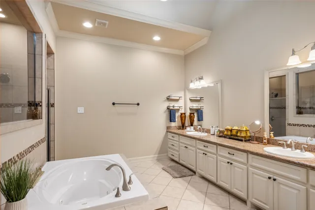 a spacious bathroom with a granite countertop sink a mirror and a bathtub