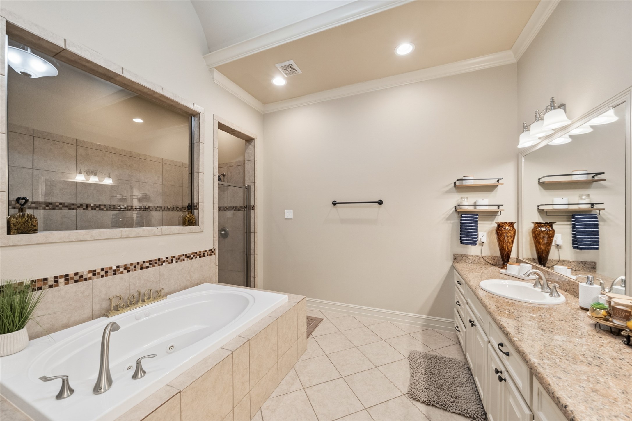 255 Capetown Way Conroe, TX 77356 - Photo 23 of 30 a spacious bathroom with a granite countertop sink a mirror and a bathtub
