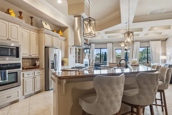 a dining hall with stainless steel appliances kitchen island granite countertop a table and chairs