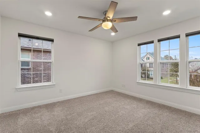an empty room with a window and a fan
