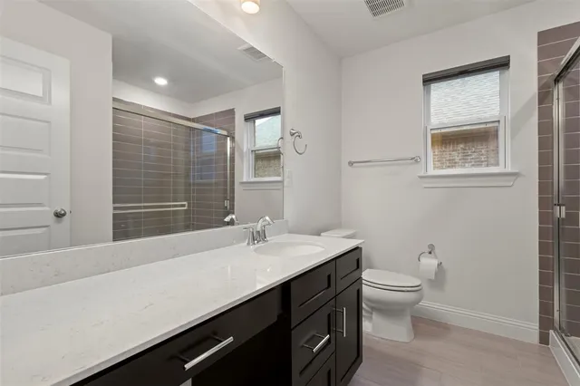 a bathroom with a sink a toilet and shower