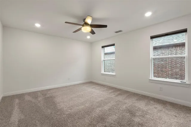 an empty room with windows and fan