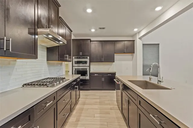 a kitchen with stainless steel appliances granite countertop a sink stove and refrigerator