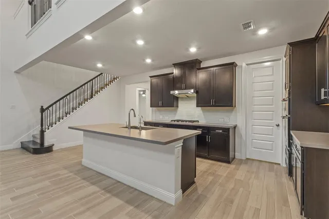 a kitchen with stainless steel appliances kitchen island granite countertop a stove and a refrigerator