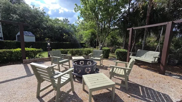 a view of a patio with a dining table and chairs with wooden floor
