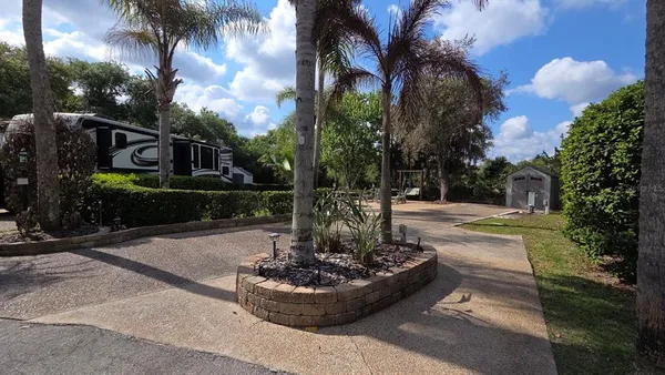 a view of a house with garden and trees