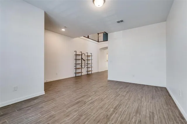 a view of a room with wooden floors and ceiling fan