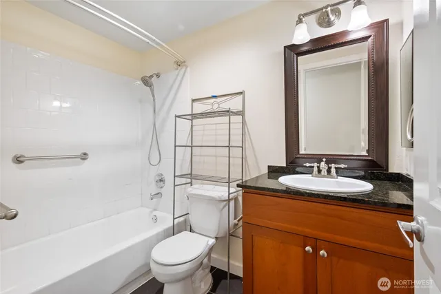 a bathroom with a granite countertop sink toilet and shower
